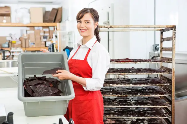 Beautiful woman with beef Jerky baking rack and container